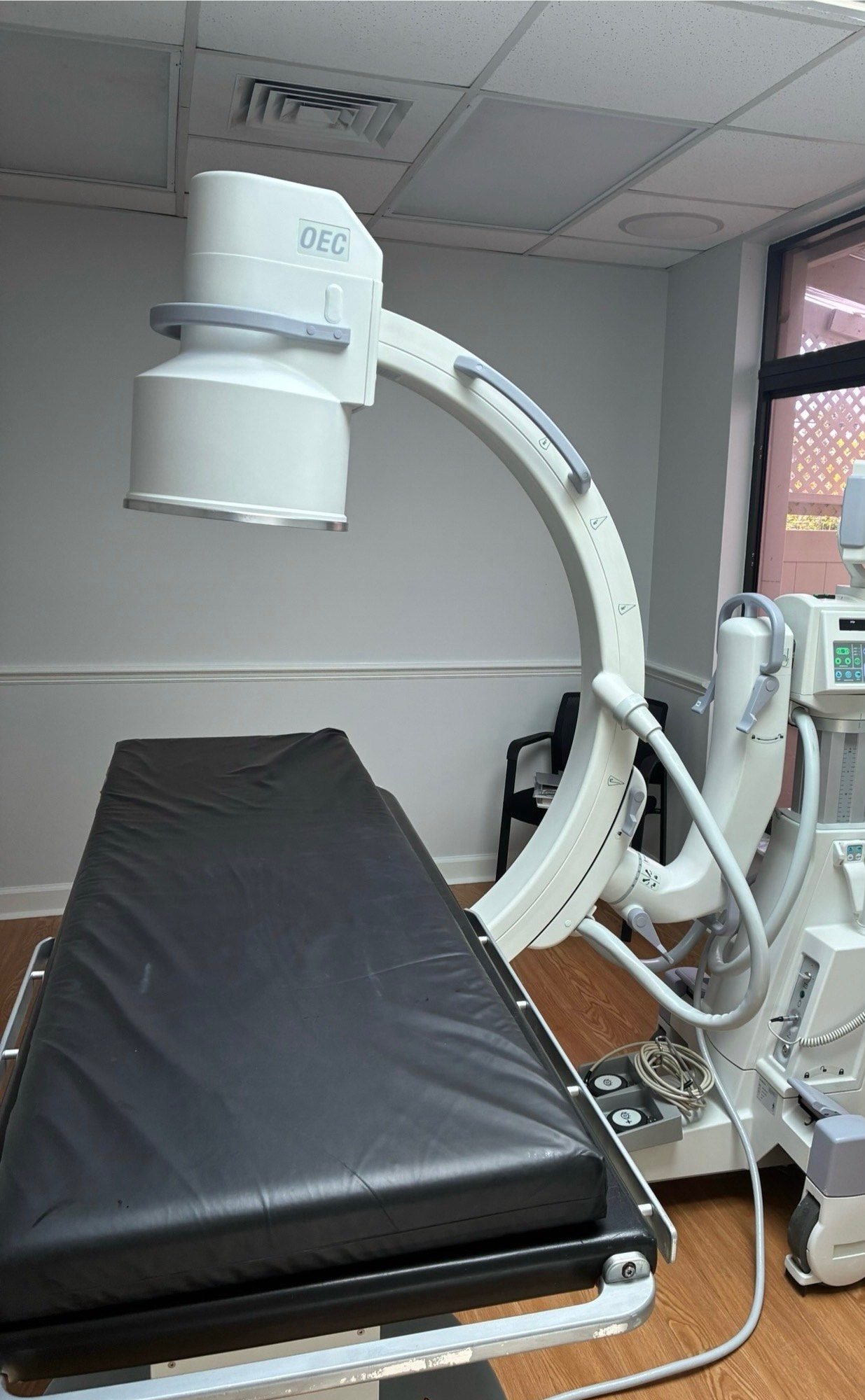 GE OEC 9900 Elite C-arm next to a procedure table