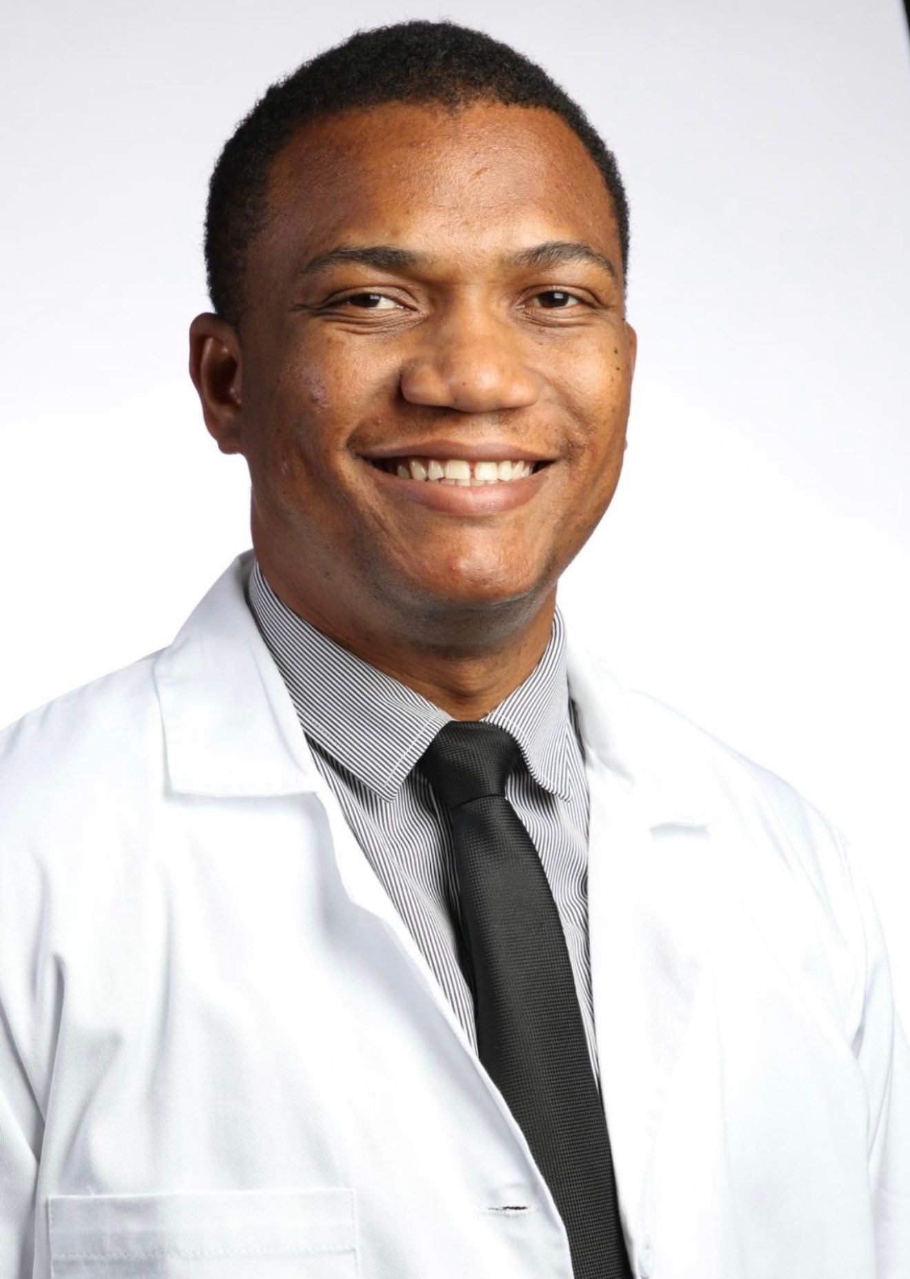 Dr. Garly R. Saint Croix, MD, smiling in a white coat
